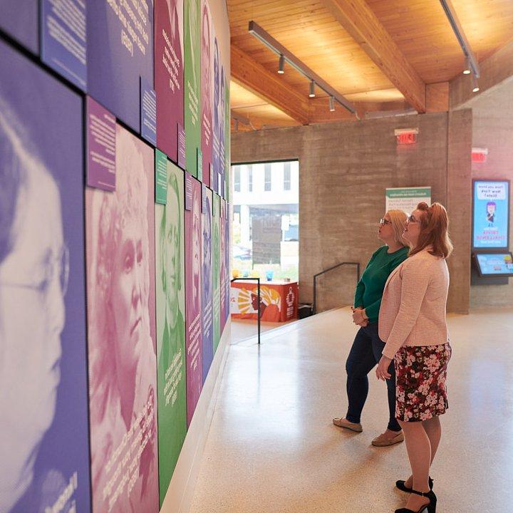 建筑内部，两个女人在看墙上的艺术品